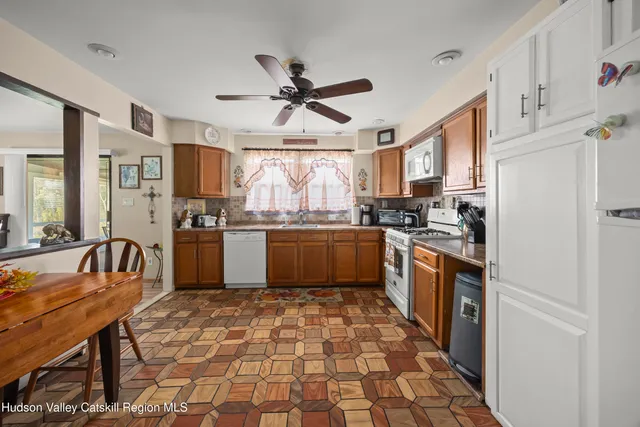 a kitchen with stainless steel appliances granite countertop a refrigerator a sink dishwasher a stove with wooden cabinets