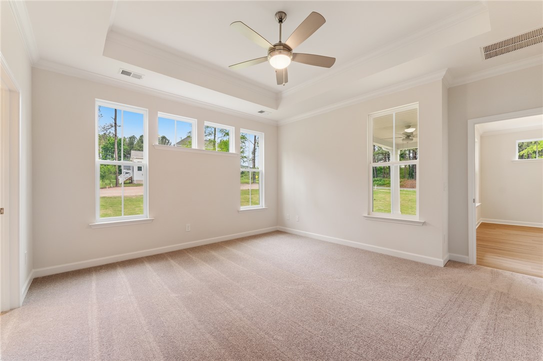 110 Lakeside Drive Anderson, SC 29621 - Photo 19 of 34 This spacious primary bedroom features soft carpeting, large windows, and an elegant tray ceiling.