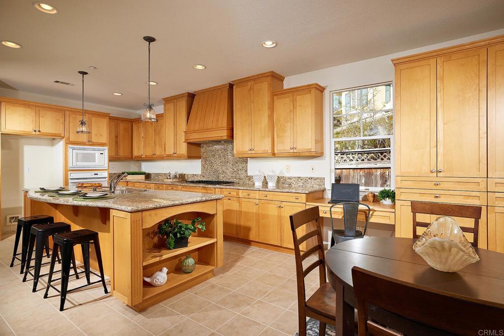 293 Star Jasmine Lane Encinitas, CA 92024 - Photo 18 of 37 a open kitchen with stainless steel appliances granite countertop a stove top oven a sink dishwasher and white cabinets with wooden floor