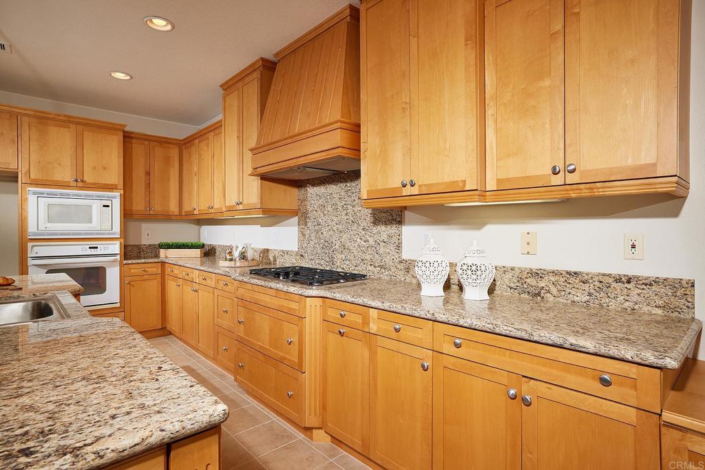 293 Star Jasmine Lane Encinitas, CA 92024 - Photo 19 of 37 a kitchen with stainless steel appliances granite countertop a sink stove and cabinets