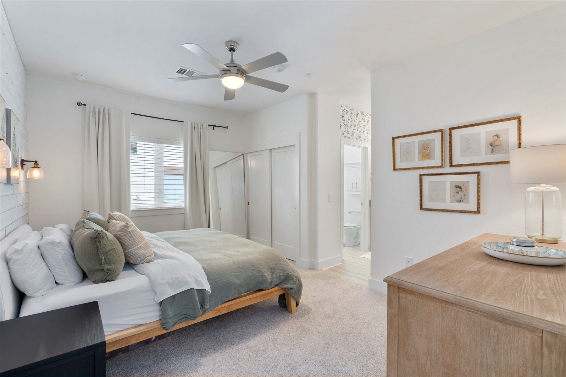 2827 Manor Road, Unit 3102 Austin, TX 78722 - Photo 10 of 18 A well-lit bedroom features plush carpeting, a modern ceiling fan, and convenient access to an en-suite bathroom.