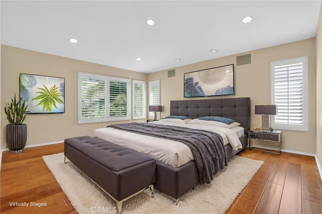 20543 Pesaro Porter Ranch Porter Ranch, CA 91326 - Photo 33 of 67 a bedroom with a large bed a rug and wooden floor