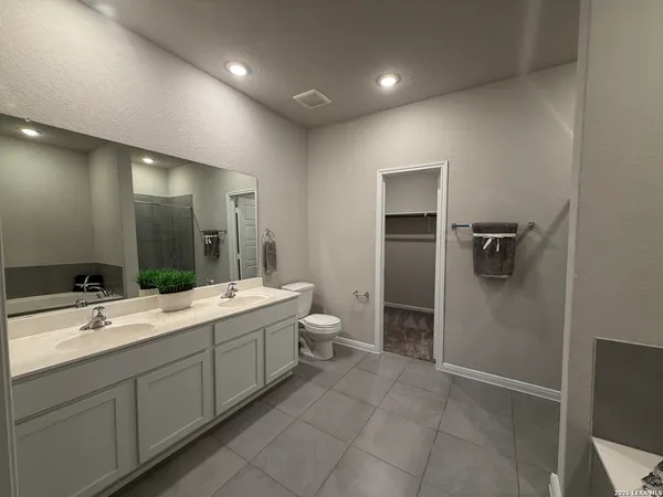 a bathroom with a double vanity sink toilet and mirror