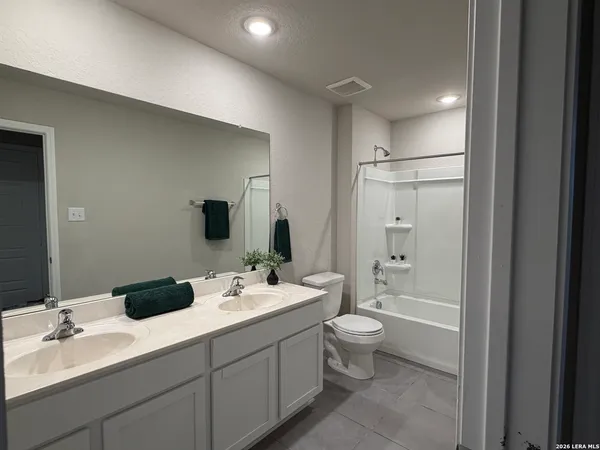 a bathroom with a double vanity sink toilet mirror and shower