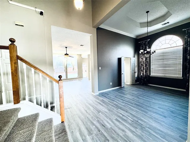 a view of a hallway with wooden floor and staircase