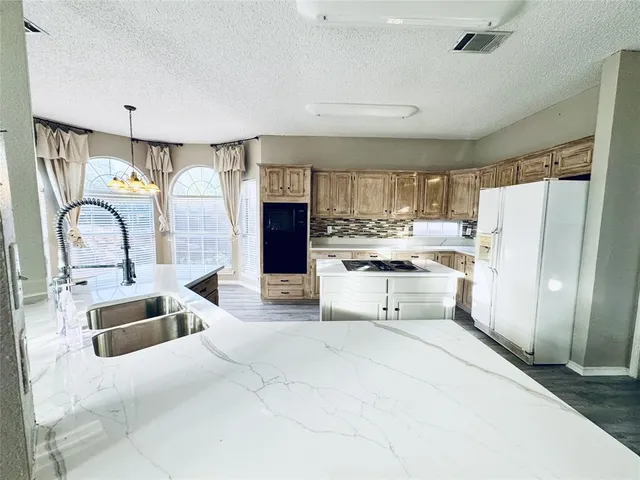 a kitchen with refrigerator and cabinets