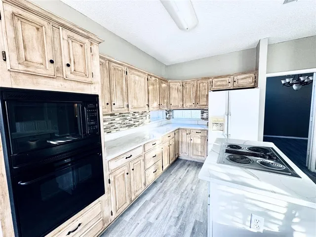 a kitchen with granite countertop a refrigerator stove and sink