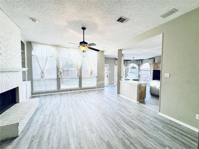 a view of a living room a wooden floor and a kitchen