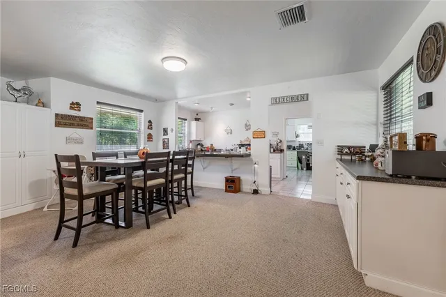 a kitchen with stainless steel appliances a dining table chairs and a refrigerator