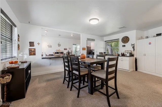 a dining hall with stainless steel appliances a dining table and chairs with wooden floor