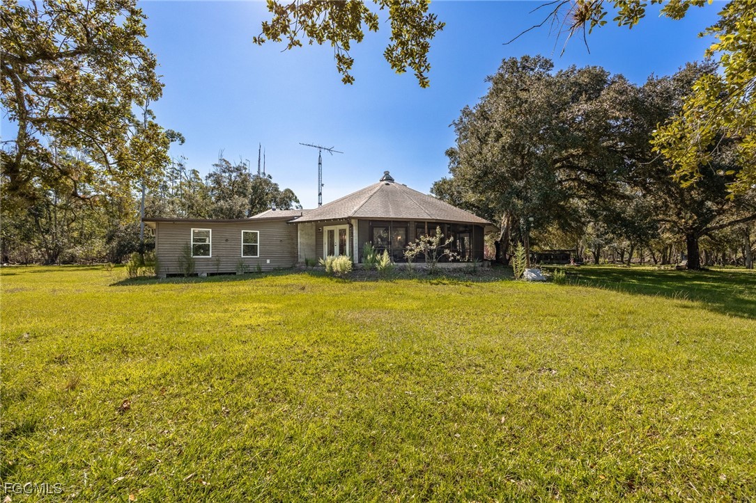 1400 Catamount Road LaBelle, FL 33935 - Photo 34 of 50 a view of a swimming pool with lawn chairs under an umbrella