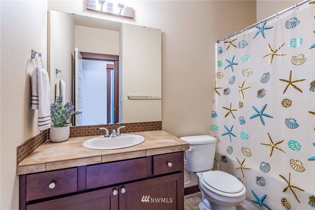 413 203rd Place Southeast Bothell, WA 98012 - Photo 34 of 38 a bathroom with a granite countertop sink a toilet and a mirror