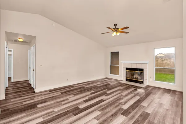 an empty room with windows and a fireplace