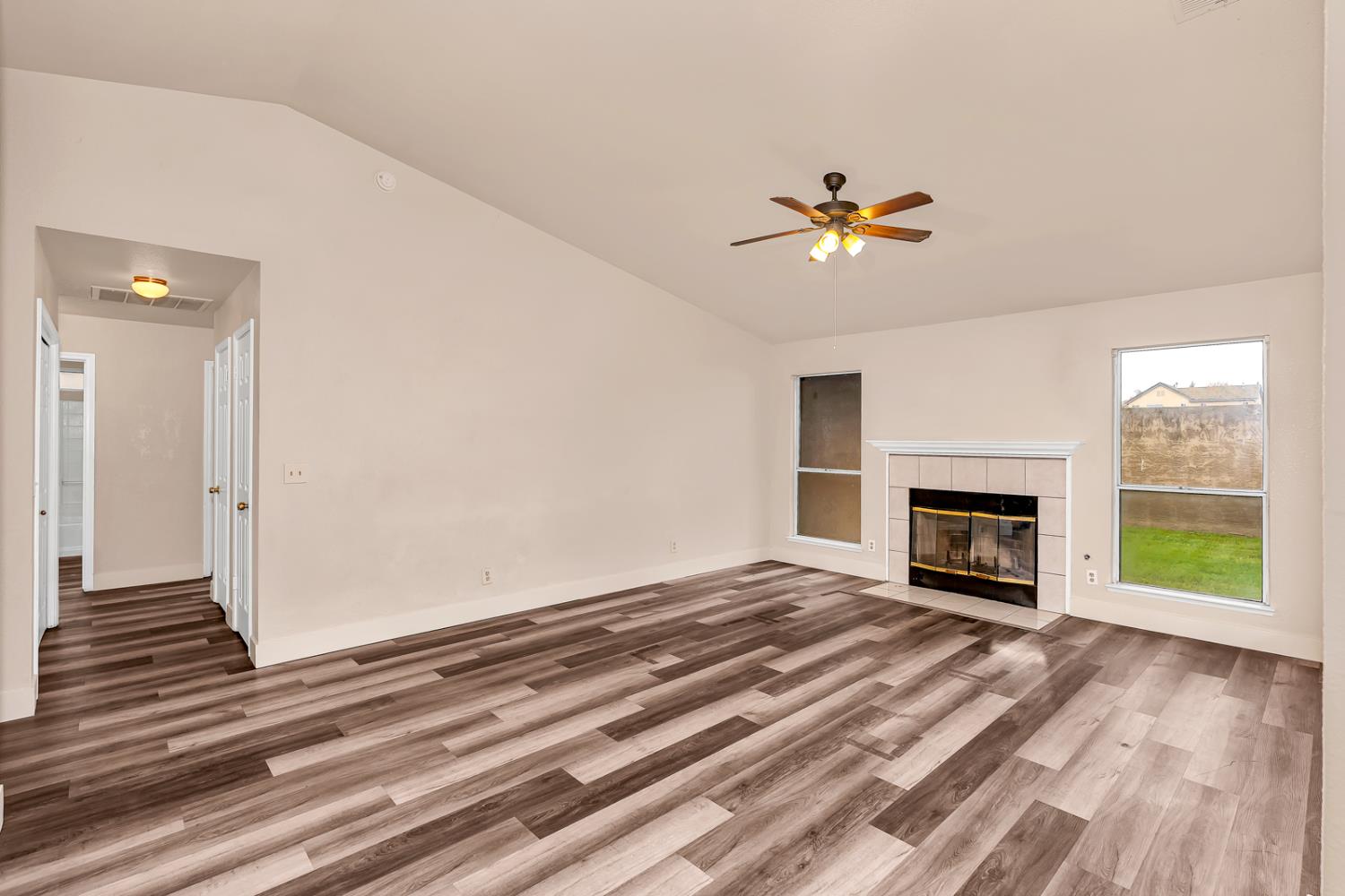 2408 Beatrice Lane Modesto, CA 95355 - Photo 11 of 36 an empty room with windows and a fireplace