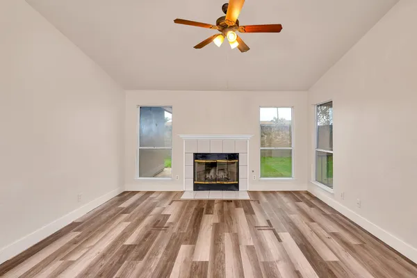 wooden floor fireplace and windows in an empty room