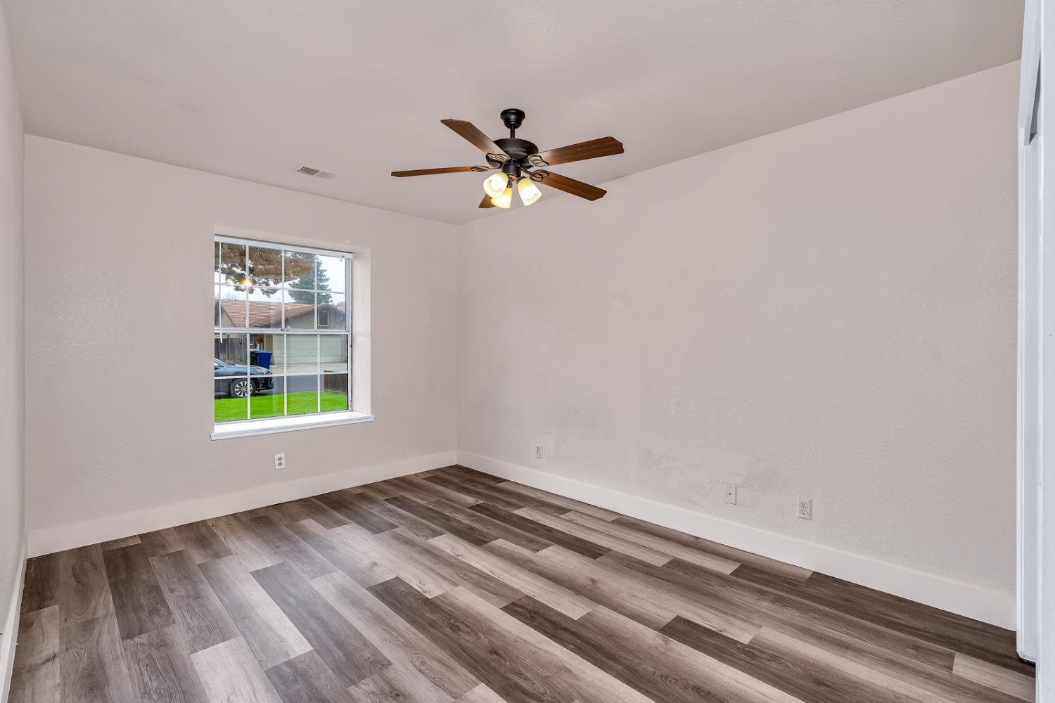 2408 Beatrice Lane Modesto, CA 95355 - Photo 17 of 36 a view of an empty room with window and wooden floor