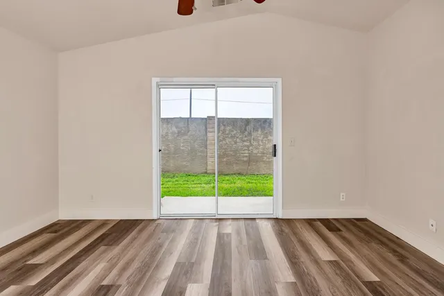a view of a livingroom with wooden floor and a ceiling fan