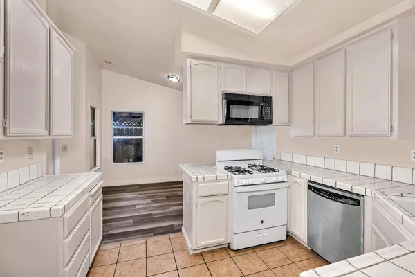 a kitchen with white cabinets and white appliances
