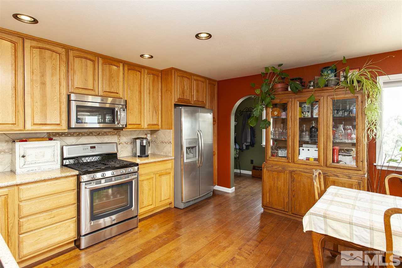 1931 Morgan Road Reno, NV 89521 - Photo 3 of 40 a kitchen with stainless steel appliances granite countertop a stove top oven a refrigerator and a cabinets with wooden floor
