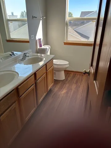 a bathroom with a granite countertop sink mirror vanity and toilet