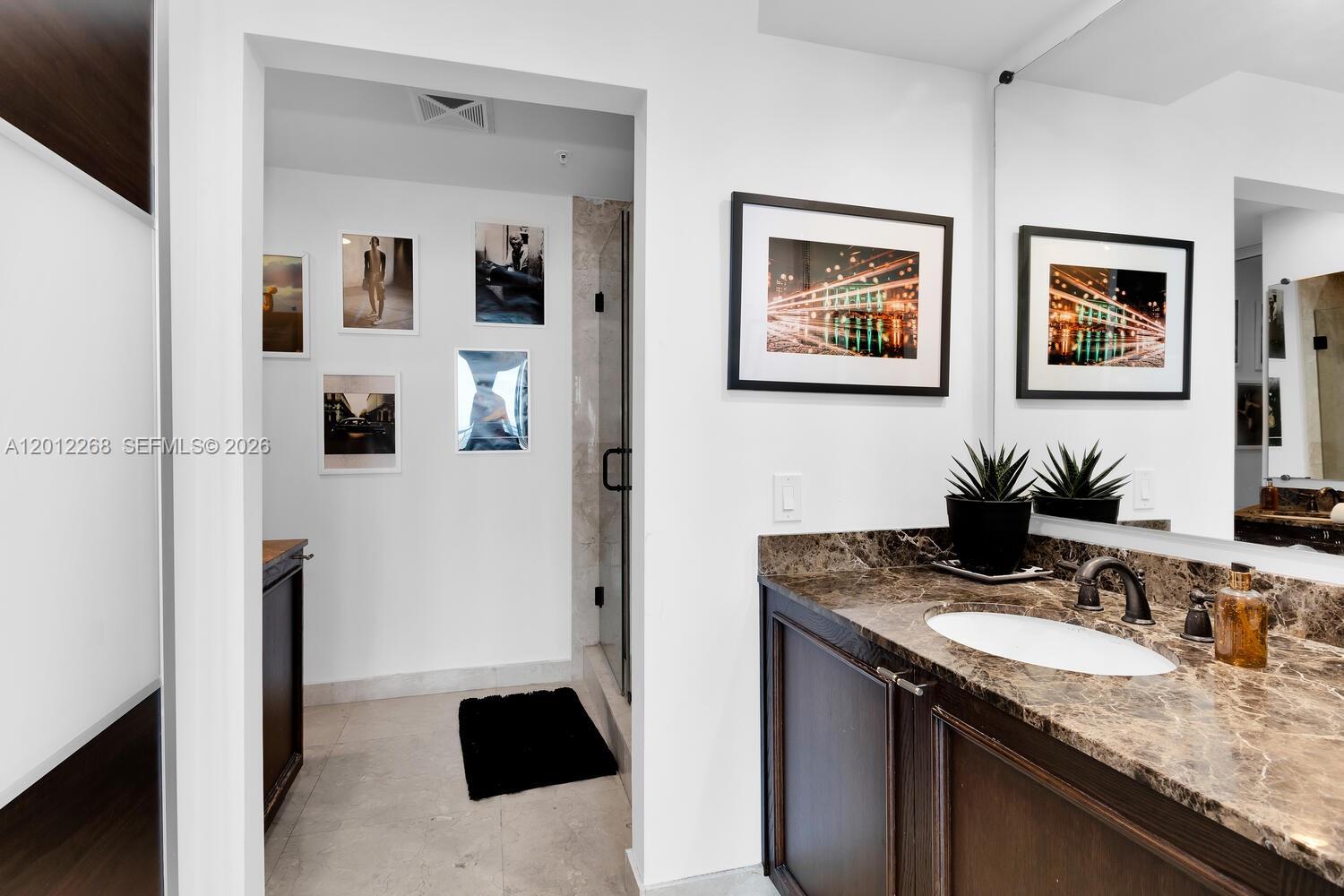 60 Southwest 13th Street, Unit 4005 Miami, FL 33130 - Photo 21 of 27 a bathroom with a granite countertop sink and a mirror