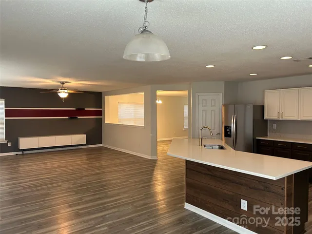 a kitchen with kitchen island a sink stainless steel appliances and cabinets