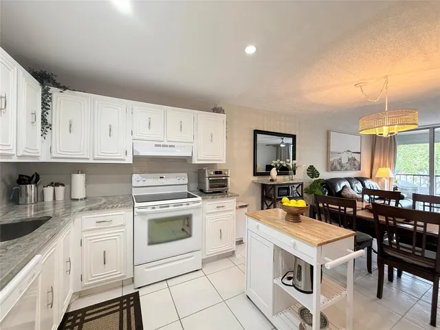 a kitchen with a stove sink and cabinets