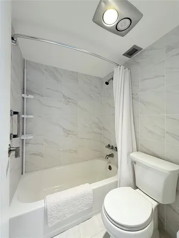 a white toilet and tub sitting next to a bathroom sink