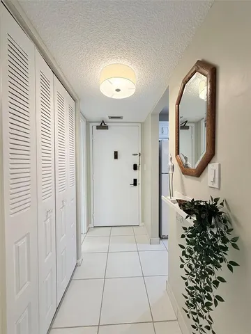 a view of a livingroom with wooden floor and a bathroom with a mirror