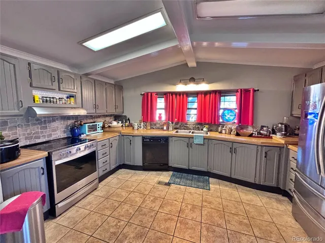 a kitchen with stainless steel appliances granite countertop a stove sink cabinets and window