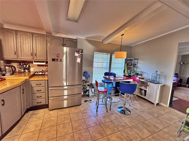 a kitchen with stainless steel appliances kitchen island granite countertop a refrigerator and cabinets