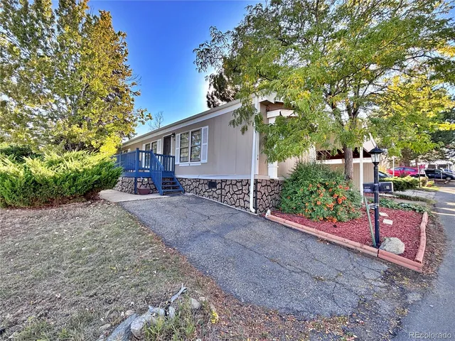 a front view of a house with a yard and potted plants