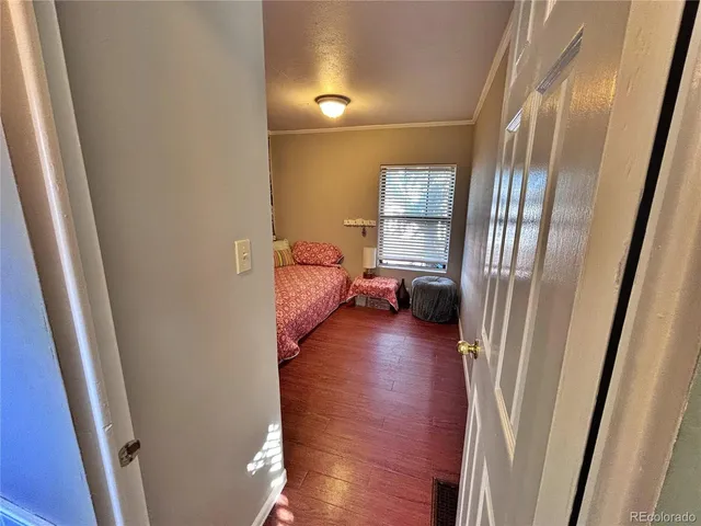 a view of a hallway with furniture and wooden floor