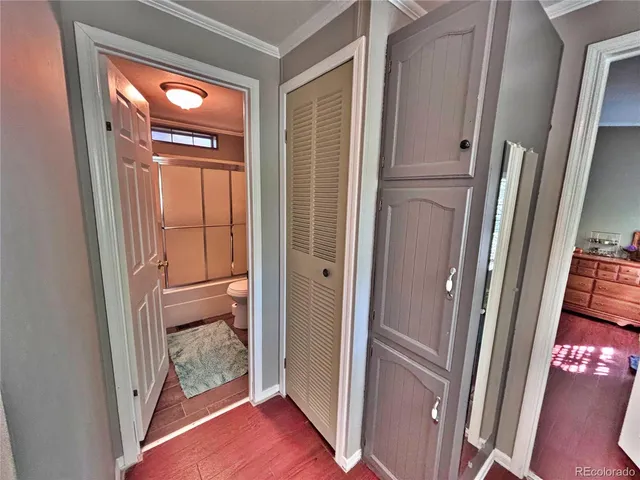 a view of a hallway with wooden floor and door