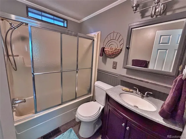 a bathroom with a granite countertop sink mirror vanity and toilet