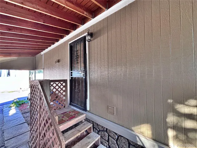 a view of a patio with table and chairs potted plants and floor to ceiling window