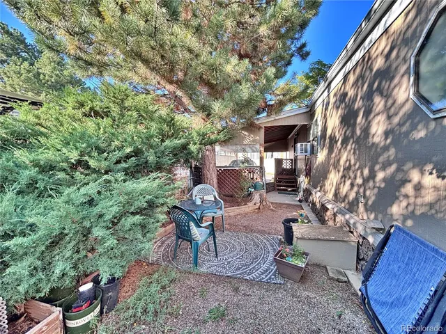 a view of a patio with chair and tables back yard of the house