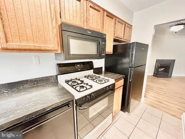 a kitchen with stainless steel appliances granite countertop a refrigerator stove top oven and sink