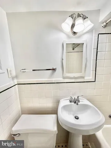 a bathroom with a sink toilet and mirror