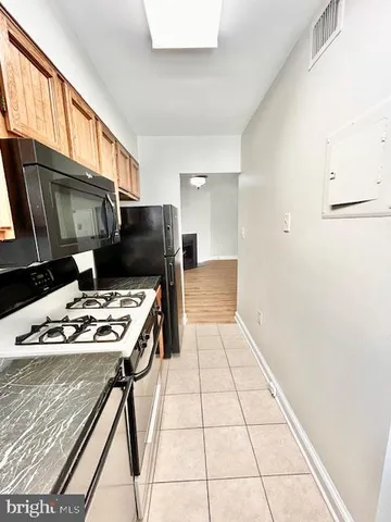 a kitchen with a stove a refrigerator and a microwave