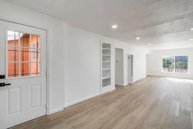 an empty room with a ceiling fan and wooden floor