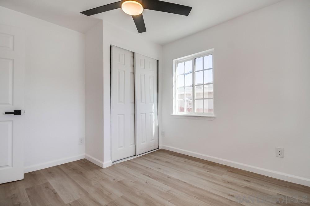796 West Washington Avenue El Cajon, CA 92020 - Photo 22 of 71 an empty room with wooden floor chandelier fan and windows