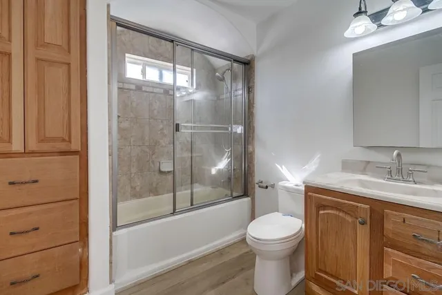 an empty room with a ceiling fan and wooden floor