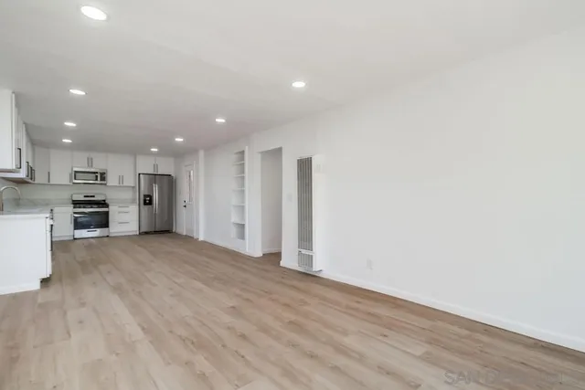 a kitchen with granite countertop white cabinets and white appliances
