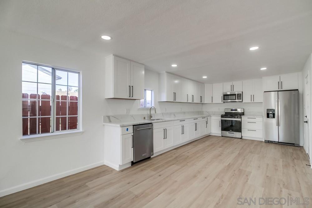 796 West Washington Avenue El Cajon, CA 92020 - Photo 8 of 71 a large kitchen with stainless steel appliances granite countertop a stove a sink dishwasher a refrigerator and white cabinets with wooden floor
