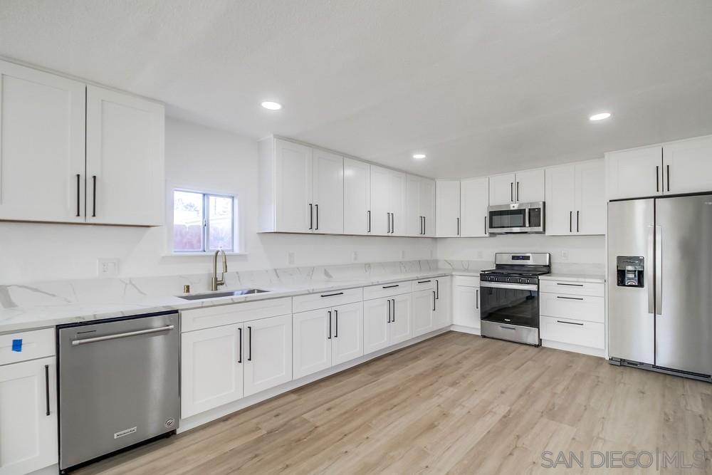 796 West Washington Avenue El Cajon, CA 92020 - Photo 9 of 71 a kitchen with granite countertop white cabinets and stainless steel appliances