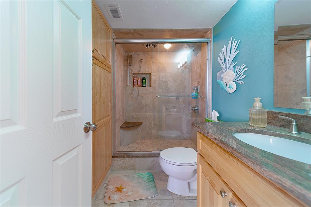 17920 Gulf Boulevard, Unit 1205 Redington Shores, FL 33708 - Photo 28 of 67 a bathroom with a granite countertop sink a toilet and shower