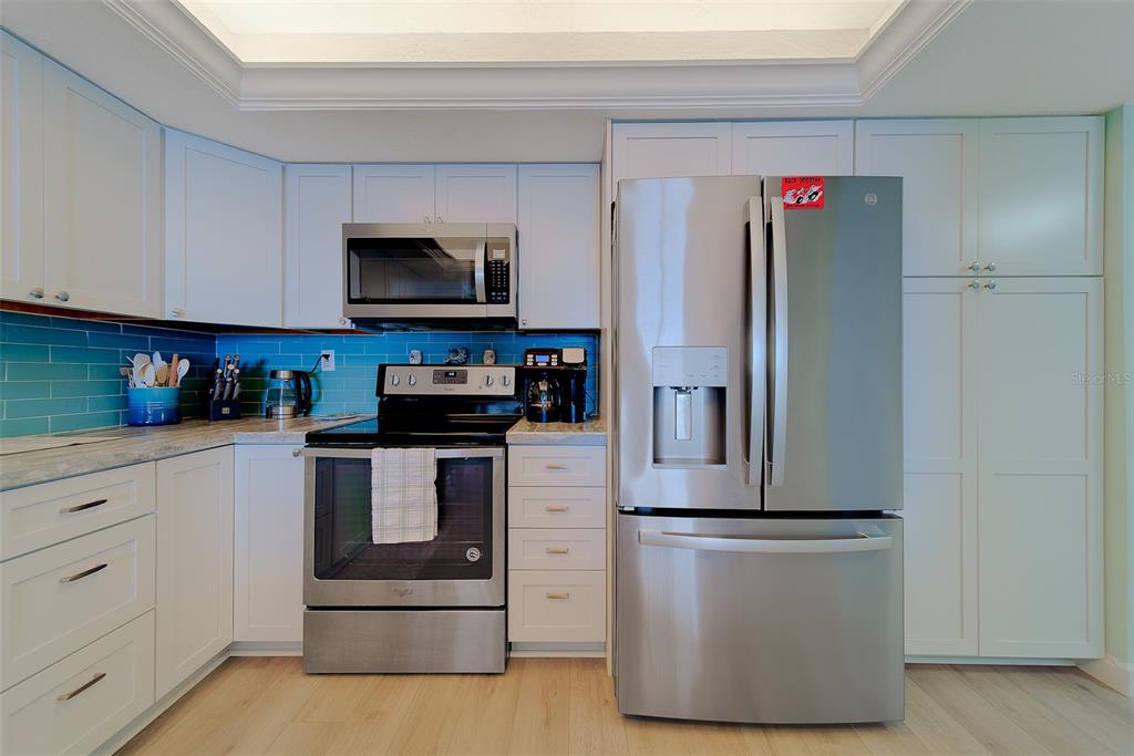 17920 Gulf Boulevard, Unit 1205 Redington Shores, FL 33708 - Photo 8 of 67 a kitchen with stainless steel appliances granite countertop a refrigerator and a stove