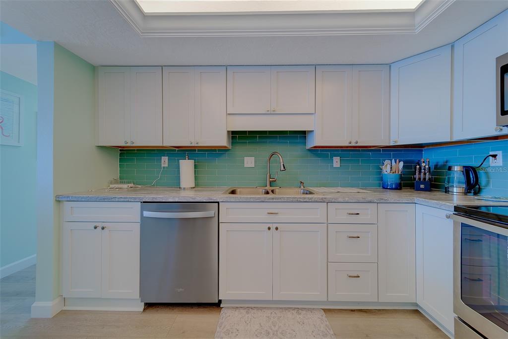 17920 Gulf Boulevard, Unit 1205 Redington Shores, FL 33708 - Photo 9 of 67 a kitchen with cabinets appliances and a sink