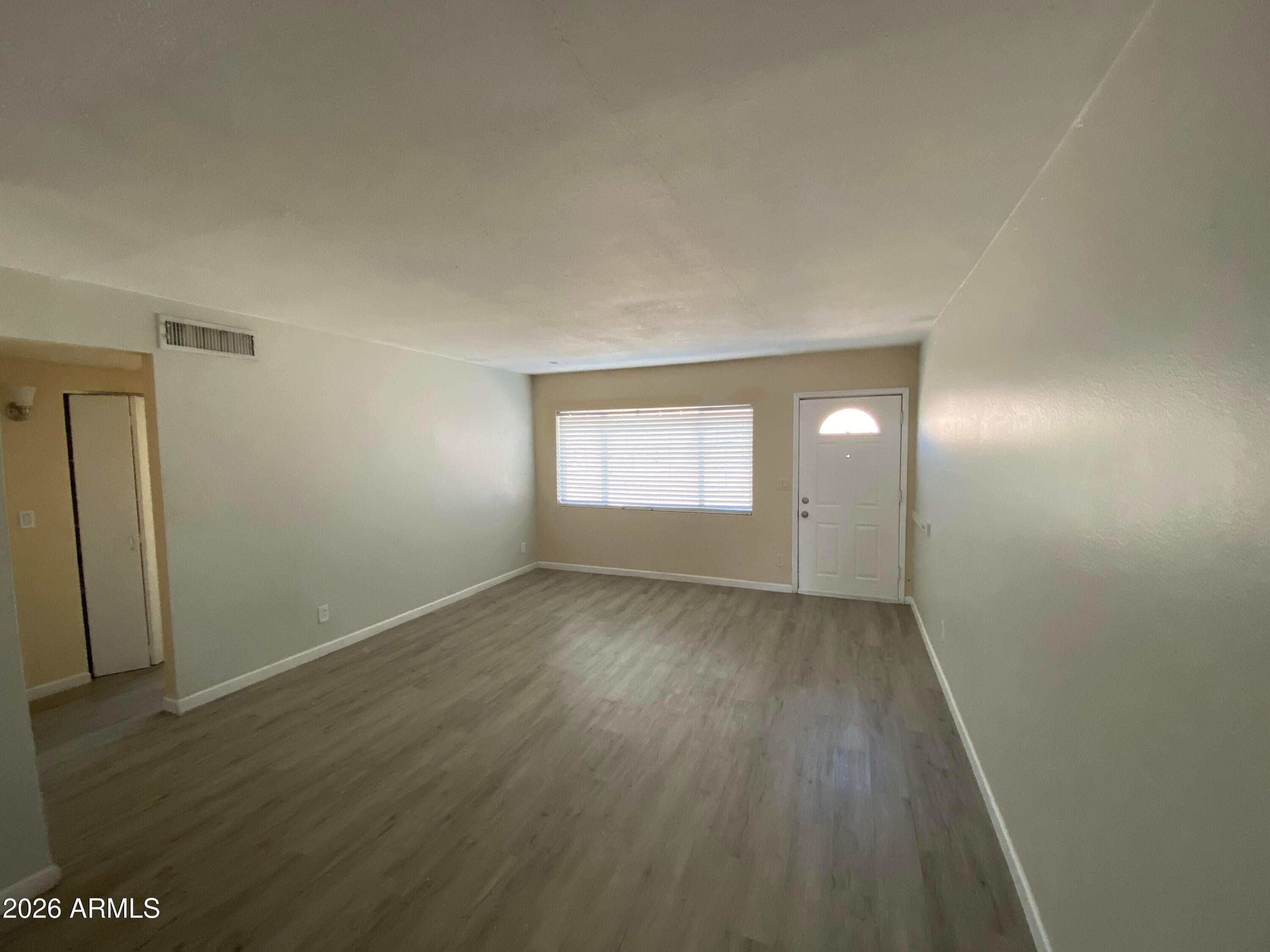 1124 North 27th Street, Unit 4 Phoenix, AZ 85008 - Photo 5 of 9 an empty room with wooden floor and windows